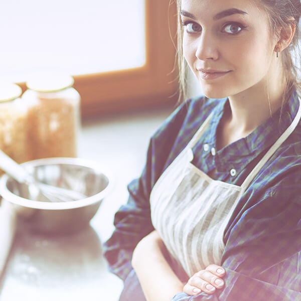Mladá dívka v kuchyňské zástěře
